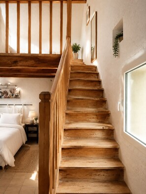 A wooden staircase leading to a bedroom with a bed, bedside table, and a window. - Le Mas d'Eylieux - House with swimming pool - South Ardèche (Saint Montan)
