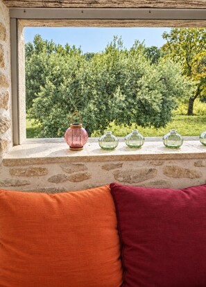 A window with a view of a garden, a pink lantern, and four glass bottles on a ledge. - Cottage · Duplex with Pool (Saint Montan)