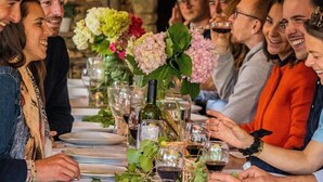 A group of people seated at a table with wine glasses and a floral centerpiece. - Cabane 3 étoiles - Piscine  - ccbfgia (Saint-Amand-de-Coly)