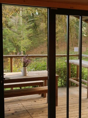 A wooden deck with a bench and a table with a vase of flowers. - Cabane 3 étoiles - Piscine  - ccbfgie (Saint-Amand-de-Coly)