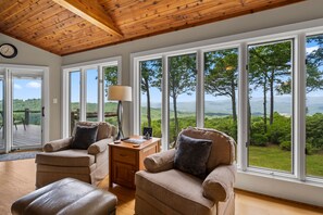 A room with large windows, a wooden ceiling, and a view of a forested landscape. - Eagleview Basecamp | Panoramic Pisgah Forest Views (Pisgah Forest)