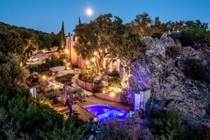 Ein luxuriöser Außenbereich mit Schwimmbad, Liegestühlen und einer gut beleuchteten Terrasse.