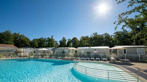 Una piscina amb gandules i un cel il·luminat pel sol.