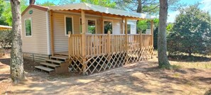 Eine kleine, eingeschossige Holzhütte mit einer Veranda und einer Treppe zum Eingang.