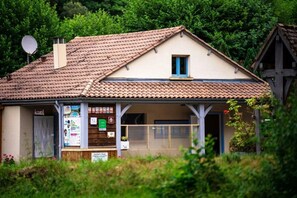 Ein kleines, eingeschossiges Gebäude mit Ziegeldach, einem sichtbaren Eingang und einer Satellitenschüssel.