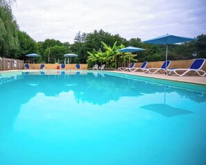 Ein Pool mit Liegestühlen und Sonnenschirmen.