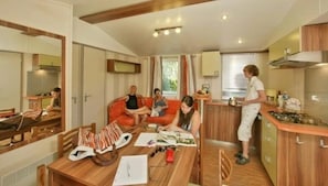 Ein kompakter Wohnraum mit Essbereich, einer Küche und einer Sitzecke mit Sofa.