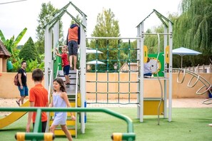 Une aire de jeux avec des structures d’escalade et une zone délimitée par un filet.