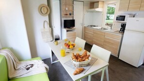 Una cocina moderna con comedor, sofá y alimentos para el desayuno sobre la mesa.