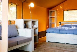 Ein Zimmer mit einem Bett, einer Couch, Regalen und einer Hängelampe.