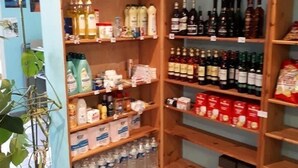 Un comerç amb prestatges plens de diverses begudes, incloent aigua embotellada, llet i begudes alcohòliques.
