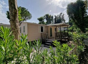 A mobile home with a porch and steps leading to a deck. - Camping 4 étoiles - Piscine  - ccbgaab (Mandelieu-la-Napoule)