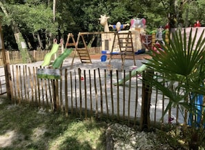 A fenced outdoor play area with swings, slides, and climbing structures. - Camping 3 étoiles - Piscine  - ccbfig0 (Saint-Fort-sur-Gironde)