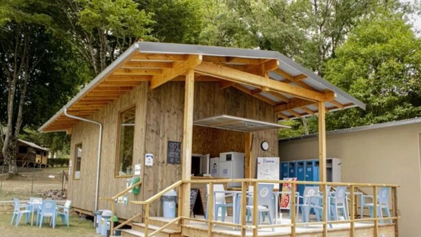 A wooden structure with a porch, steps, and a small building with a window and a door. - Camping 3 étoiles - ccbfigd (Ombrée d'Anjou)
