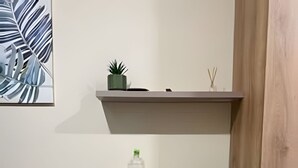 A small room with a desk, chair, shelves, and a painting. - Suite Premium (Medellín)