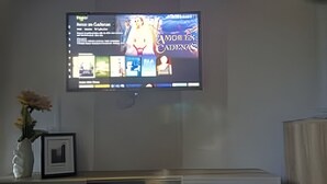 A television mounted on a wall displaying a movie or show. - Suite Premium (Medellín)