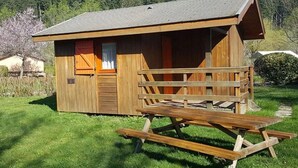 A wooden cabin with a sloped roof, a wooden door, and a small porch.