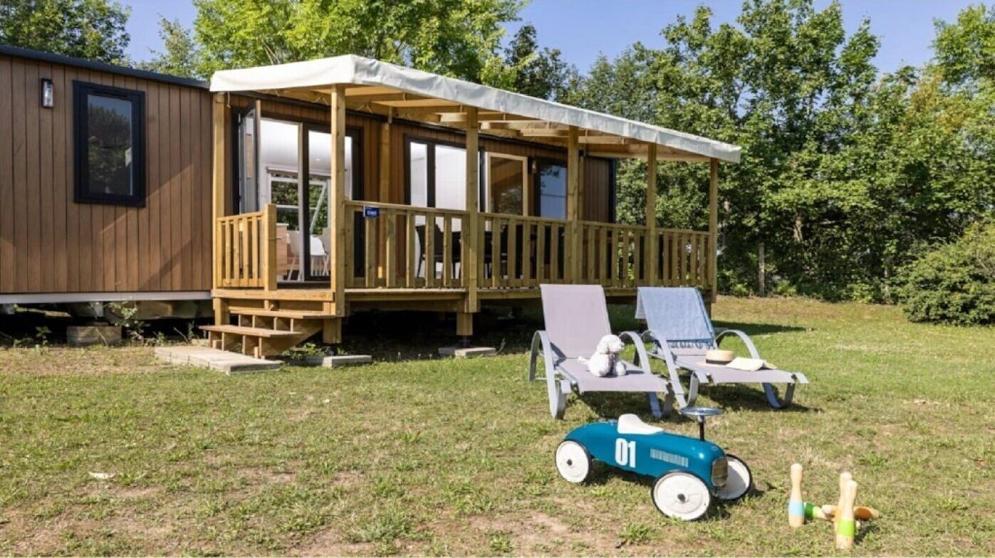 A wooden deck with lounge chairs and a toy car.