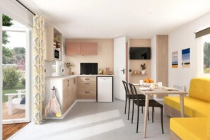 Eine kleine Küche mit Essbereich, einem Kühlschrank und einem Fernseher.