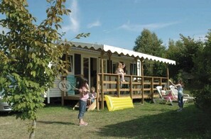 A small, single-story building with a porch and a slide. - Camping 4 étoiles - Parc aquatique - ccbfheh (La Romieu)