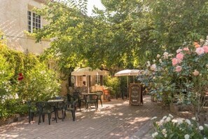 Eine Terrasse mit Sitzgelegenheiten im Freien, einer kleinen Struktur und einem Schild.