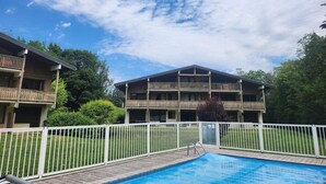 Un edificio su due piani con una piscina di fronte.
