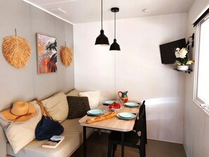 Un rincón comedor acogedor con mesa de madera, sillas negras y un sofá con cojines.