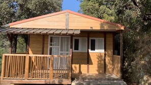 Une petite cabane en bois avec une véranda, une fenêtre et une porte.