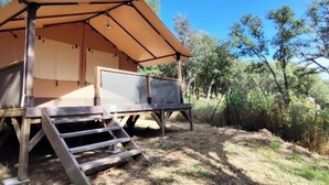 A tent-like structure with a ramp leading to a platform, surrounded by trees. - Camping 4 étoiles - Piscine  - ccbfiff (Olmeto)