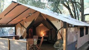 A tent with a covered porch, wooden furniture, and a small table. - Camping 4 étoiles - Piscine  - ccbfiff (Olmeto)