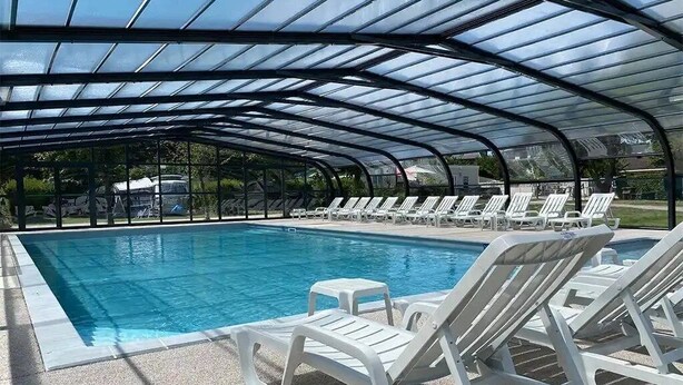 A covered swimming pool with lounge chairs and a small table. - Chalet 3 étoiles - Piscine  - ccbfhif (Rue)