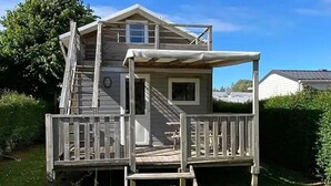 A two-story wooden house with a porch, a staircase, and a small window. - Chalet 3 étoiles - Piscine  - ccbfhif (Rue)