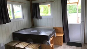A room with a table, benches, two windows with curtains, and a door. - Chalet 3 étoiles - Piscine  - ccbfhif (Rue)