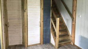 A room with a wooden staircase, two doors, and a blue wall. - Chalet 3 étoiles - Piscine  - ccbfhif (Rue)