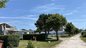 A rural road with houses, a large tree, and a clear sky. - Chalet 3 étoiles - Piscine  - ccbfhif (Rue)