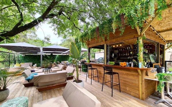 Ein Außenbereich mit Holzterrasse, einer Bar und Sitzgelegenheiten.