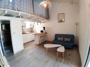 A compact living space with a kitchenette, a dining area, a sofa, and a staircase. - Camping 4 étoiles - Piscine  - ccbfic0 (Carqueiranne)