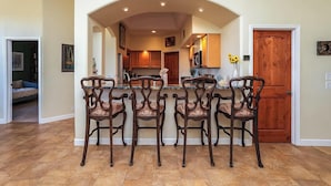 A dining area with a central island, four chairs, and a wooden door.