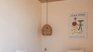 Een moderne woonkamer met een modulaire bank, een kleine houten salontafel, een hanglamp en een kunstwerk aan de muur.