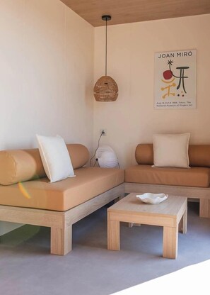 A modern living room with a sectional sofa, a small wooden coffee table, a hanging light fixture, and a wall-mounted artwork. - Camping 4 étoiles - Piscine  - ccbfici (Carqueiranne)