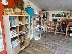 A boutique store with wooden shelves, a variety of products, and a small plant.