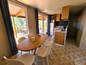 Eine kleine Küche mit Kühlschrank, Mikrowelle und Holzschränken.