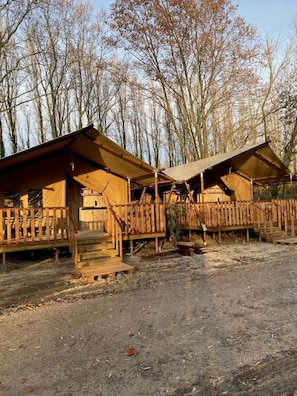 Two wooden cabins with attached porches, surrounded by trees. - Camping 2 étoiles - Piscine  - ccbfiii (Villeneuve-lès-Avignon)