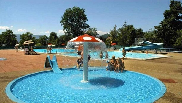 A water park with a central water feature, slides, and a pool area. - Camping 3 étoiles - Piscine  - ccbgaad (Mens)