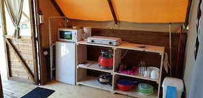 Cocina compacta equipada con microondas, cafetera y un refrigerador pequeño.