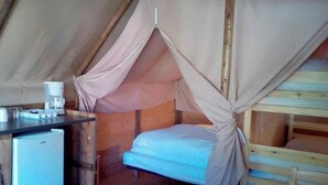 A small, enclosed room with a bed, a desk with a coffee maker, and a refrigerator. - Camping 3 étoiles - Piscine  - ccbgaad (Mens)