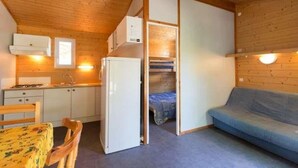 Et lille værelse med tekøkken, sofa og seng.