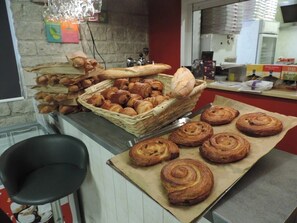 Eine Theke in einer Bäckerei mit Gebäck, einem Stuhl und Küchengeräten.