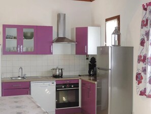 Eine kleine Küche mit Geschirrspüler, Backofen und Kühlschrank.