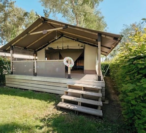 Ein überdachter Außenbereich mit Holzterrasse und Treppe hinauf.
